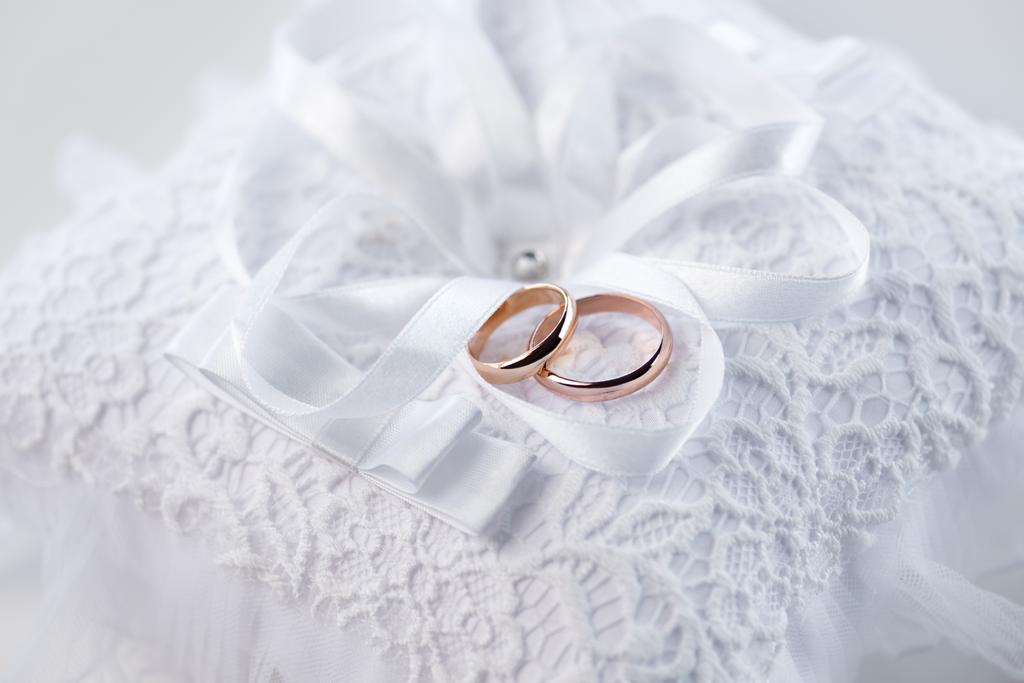 stock photo wedding rings on lace pillow