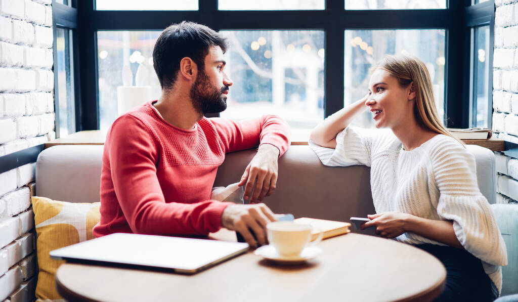 stock photo caucasian male female sitting cafeteria table discussing trip plan leisure