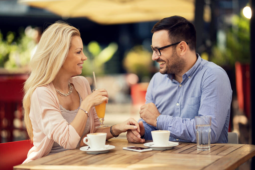 stock photo smiling couple holding hands talking each other while having date