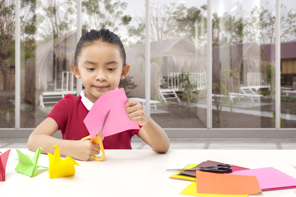 stock photo asian little girl cutting paper home