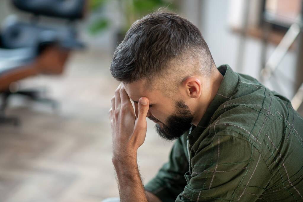 stock photo bearded man wearing checked shirt having strong headache 1731692817