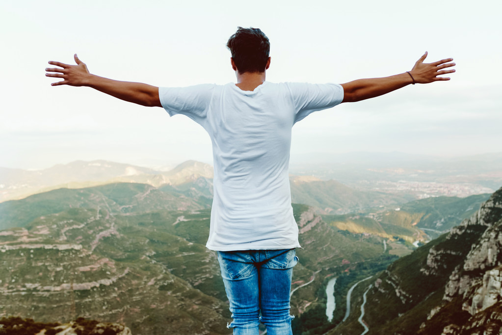 stock photo handsome young man enjoying nature at mountain peak